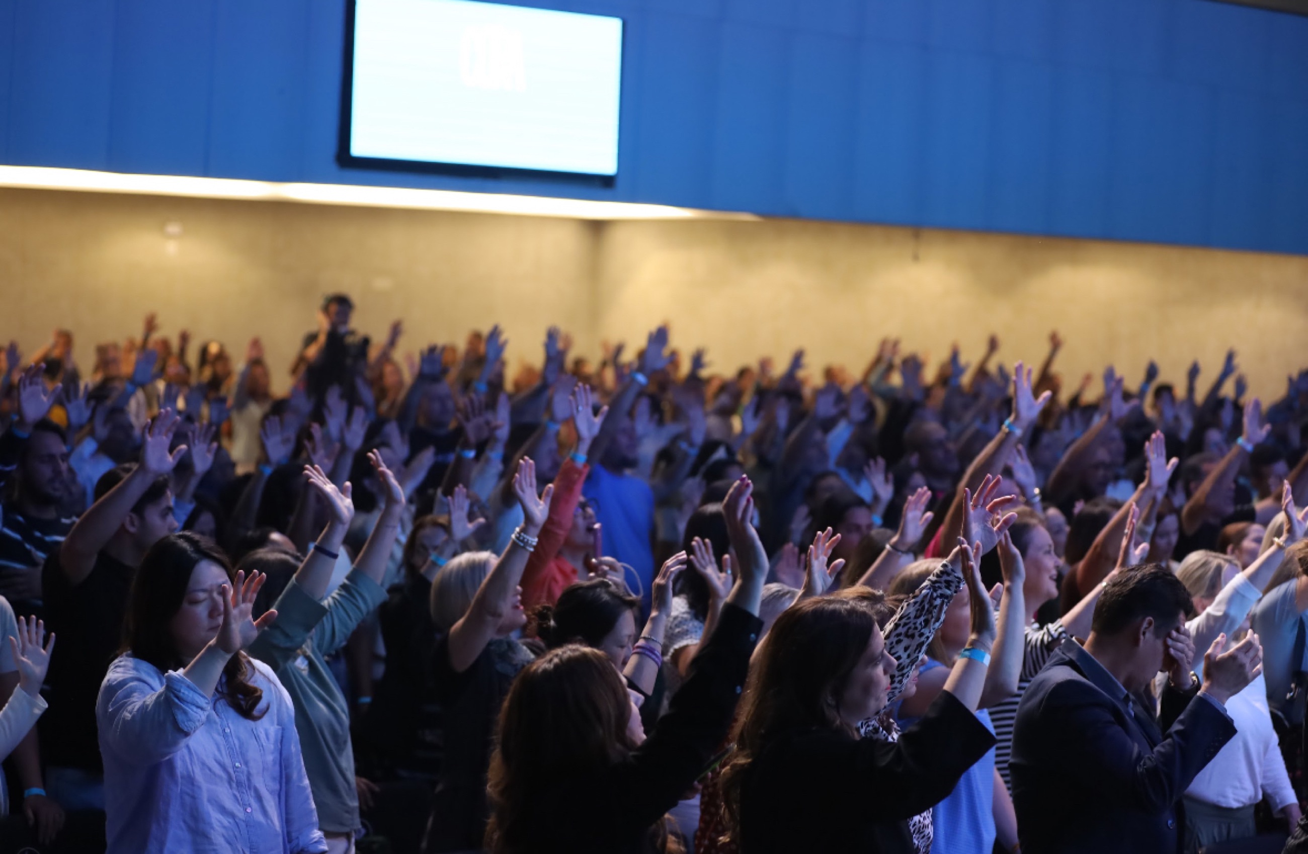 Agape congregation in worship, hands raised
